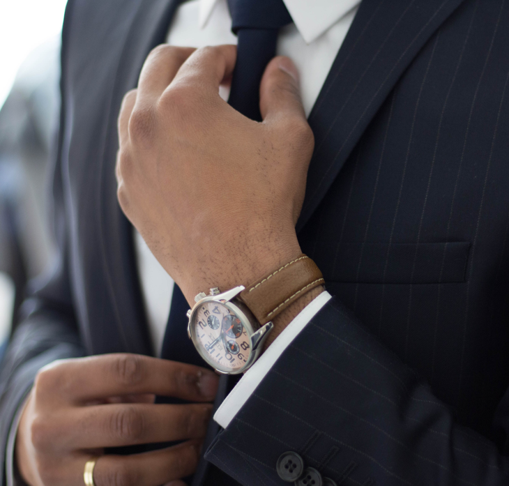 a businessman adjusts his tie on his suit